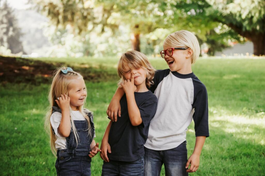 aîné, cadet et benjamine dans un parc font les clowns