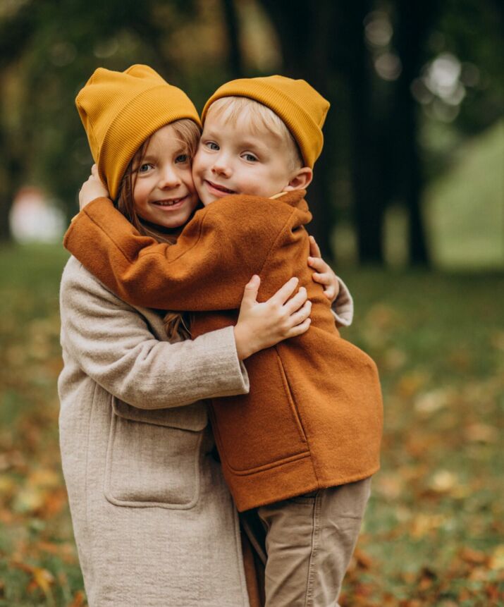 frère et soeur qui se prennent dans le bras dans un parc