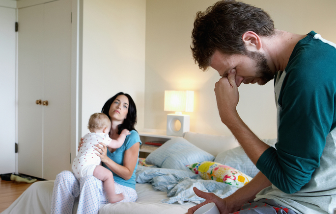 parents and baby girl (9 12 months) in bedroom, man holding head